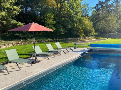 - une rangée de chaises et un parasol à côté de la piscine dans l'établissement demeure de luxe, piscine sauna billard pétanque, à Yèvre-le-Châtel