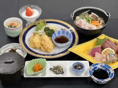 a table with plates of food and bowls of food at ホテルベイグランド国東 in Kunisaki