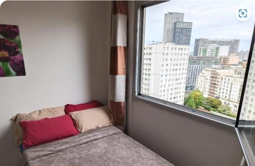 Cette chambre avec vue dispose d'une fenêtre avec un canapé. dans l'établissement Grand appartement proche métro quartier la defense, à Courbevoie