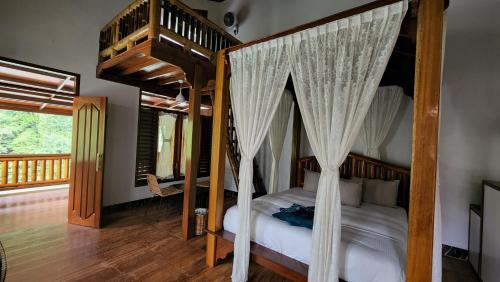 a bedroom with a canopy bed and a staircase at Sam's Bungalows And Treks in Bukit Lawang