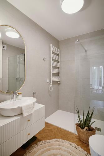 a white bathroom with a sink and a shower at Apartament Sienkiewicza 22B in Zamość