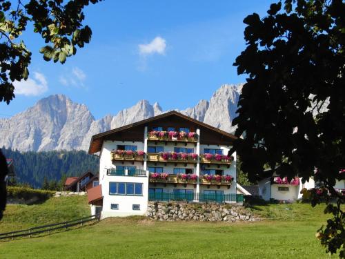 a hotel in the mountains with mountains in the background at Aparthotel Sunrise in Ramsau am Dachstein