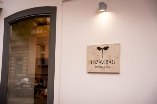 a sign on the side of a building with a door at Tiszavirág Szeged in Szeged