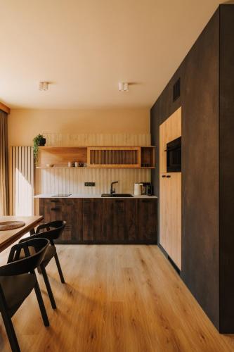 a kitchen with wooden floors and a table and chairs at Apartament Riders Lodge Sopot in Sopot