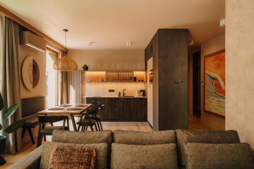 a living room and kitchen with a couch and a table at Apartament Riders Lodge Sopot in Sopot