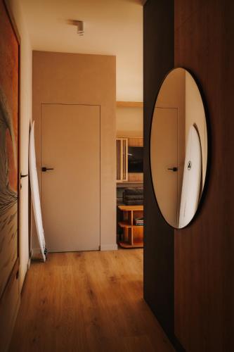 a hallway with a mirror on a wall and a door at Apartament Riders Lodge Sopot in Sopot