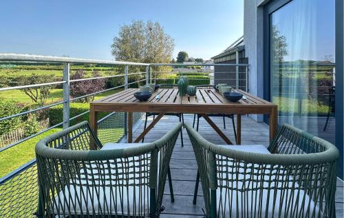a wooden table and two chairs on a balcony at 2 Bedroom Beautiful Apartment In Bièvre in Bièvre