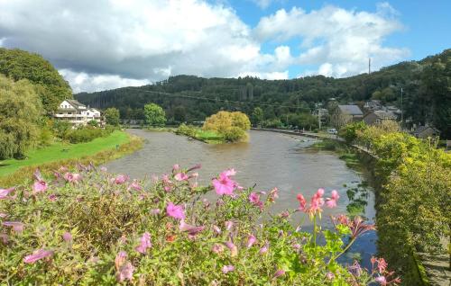 a river in a town with pink flowers at 2 Bedroom Beautiful Apartment In Bièvre in Bièvre
