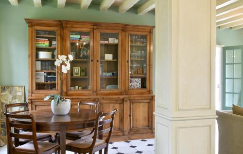 a dining room with a table and chairs and a wooden cabinet at Beautiful Home In Yèvre-La-Ville in Yèvre-la-Ville