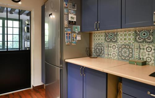 a kitchen with blue cabinets and a refrigerator at Beautiful Home In Yèvre-La-Ville in Yèvre-la-Ville