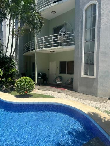 a blue swimming pool in front of a house at Villa Verde 2 Casa 14 in Tamarindo