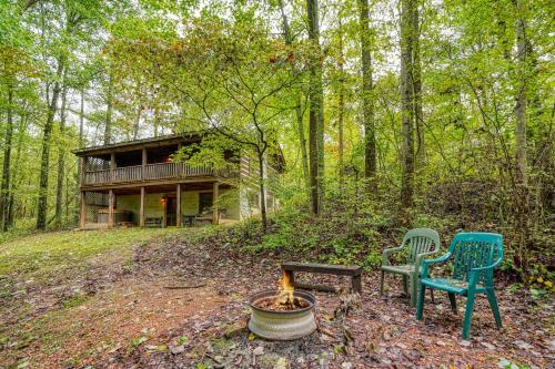 a cabin in the woods with two chairs and a fire at Chickasaw in Logan