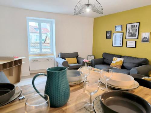 - un salon avec un canapé et une table avec des verres à vin dans l'établissement Chez Lulu - 5 lits- proche CNPE - Gare, à Ambérieu-en-Bugey