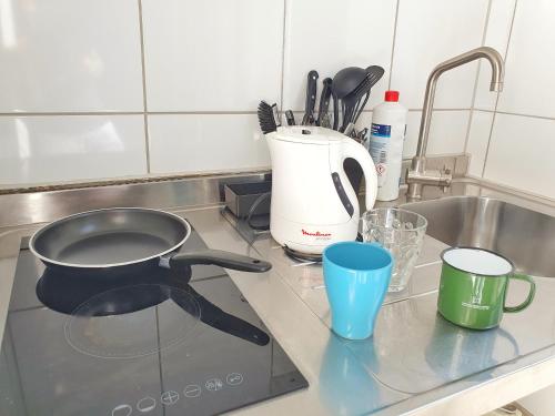 a kitchen counter with a frying pan and a sink at Aparthotel B & L in Bremen