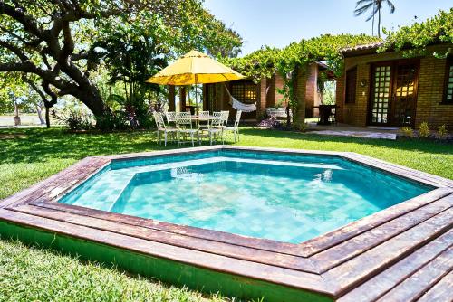 een zwembad met een tafel en een parasol bij Casa Barra Nova in Cascavel