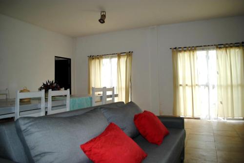 a living room with a gray couch with red pillows at Suinda casa de campo in Corrientes