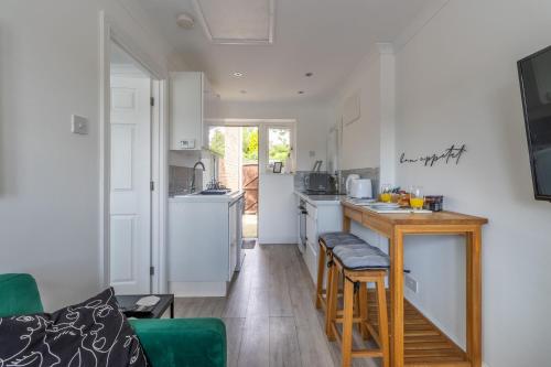 a kitchen with white cabinets and a counter top at Stylish one bedroom garden suite in Winsford