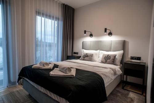 Un dormitorio con una cama grande con toallas. en Apartament Pieniny Stylchyn 90 nad jeziorem przy ścieżce Velo Czorsztyn, en Kluszkowce