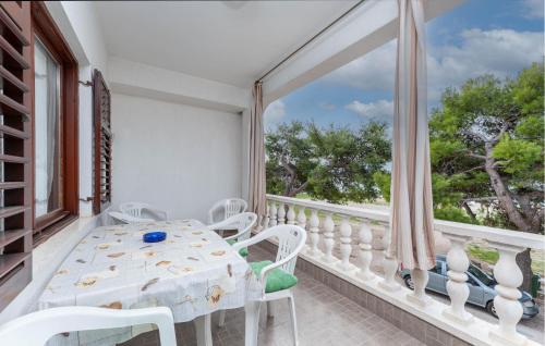 a white table and chairs on a balcony with a window at Beach Front Apartment in Sveti Filip i Jakov