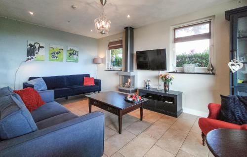 a living room with blue couches and a tv at Lovely Home In Boekel With Sauna in Boekel