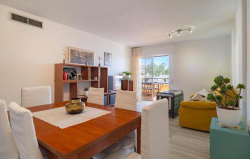 a dining room with a wooden table and white chairs at Nice Apartment In Aguadulce With Wifi in Aguadulce