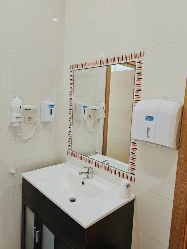a bathroom with a sink and a mirror at Junção - Apartamentos Completos in Miranda do Douro