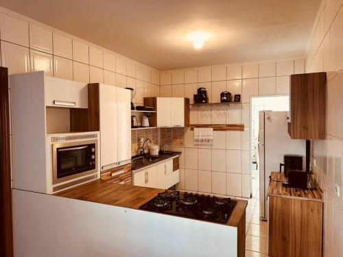 a kitchen with white cabinets and a stove top oven at Apartamento Poços de Caldas in Poços de Caldas