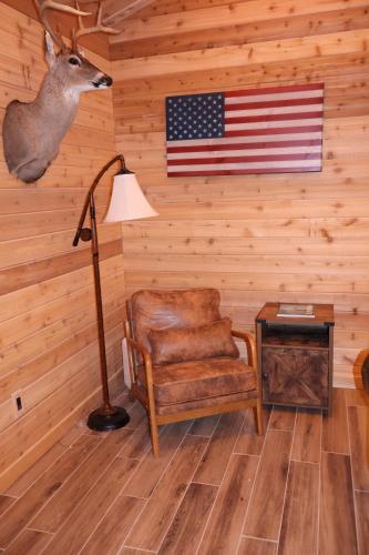a room with a lamp and a chair and an american flag at Cozy Cabin Retreat for Your Perfect Getaway in Imperial