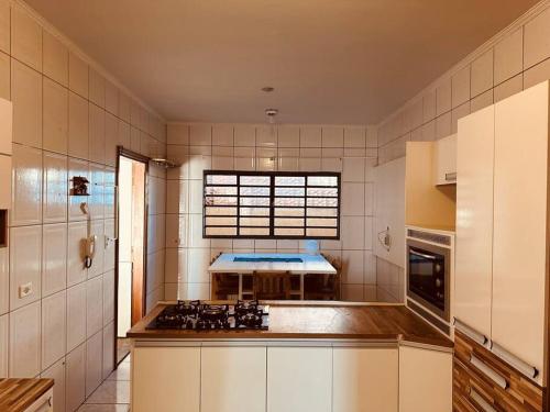 a kitchen with a stove and a sink in it at Apartamento Poços de Caldas in Poços de Caldas