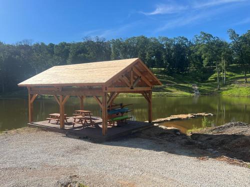 a gazebo with a picnic table on a lake at Cozy Cabin Retreat for Your Perfect Getaway in Imperial