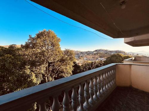a balcony with a view of trees and mountains at Apartamento Poços de Caldas in Poços de Caldas