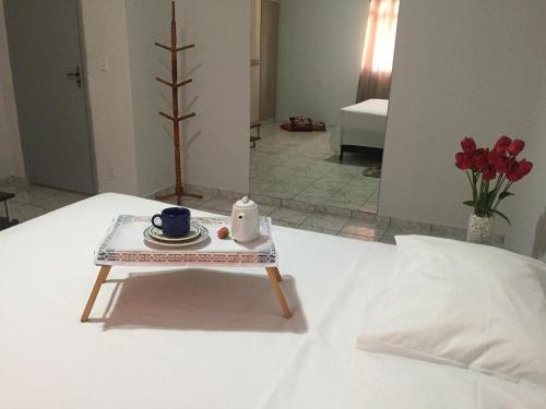 a table with a tea set on a bed at Zaffir Apartamento in Várzea Grande