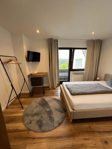 1 dormitorio con 1 cama, TV y alfombra en Pension Zur Linde, en Geisfeld
