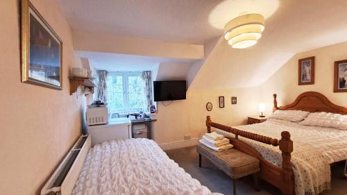 a bedroom with two beds and a kitchen with a window at Coynant Farm Guesthouse - Farm Park Stay in Swansea