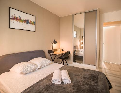 une chambre avec un lit avec deux serviettes dessus dans l'établissement Le Gatsby - Chambre 1 - Prox Hypercentre, à Troyes