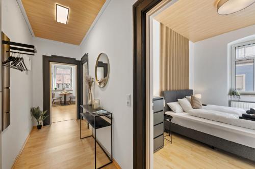 a bedroom with a bed and a hallway with a table at Modernes Appartementhaus mit Self-Checkin im Herzen der Stadt in Bad Kissingen
