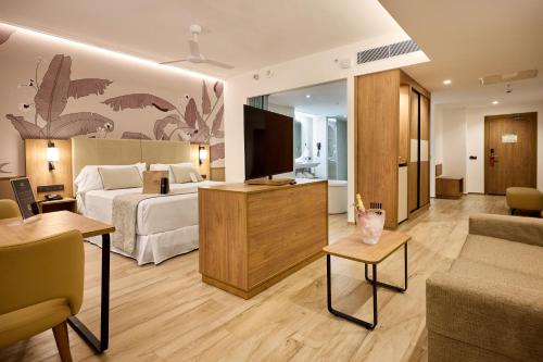 a hotel room with a bed and a living room at Riu Palace Bavaro - All Inclusive in Punta Cana