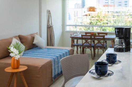 una sala de estar con un sofá y una mesa en Apartamento incrível beira mar, en Natal