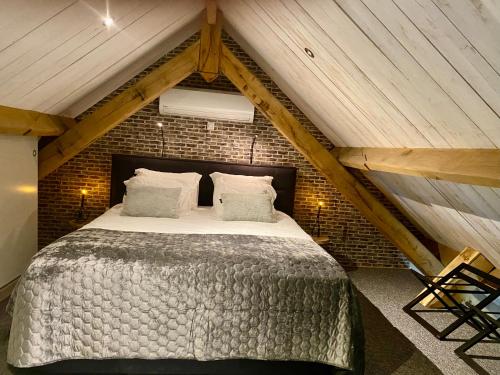a bedroom with a large bed in a attic at Antoniushofke in Asten
