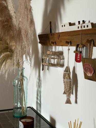 a table with a vase and a shelf with a ship on the wall at Esplanada do Ilhéu in Vila Franca do Campo