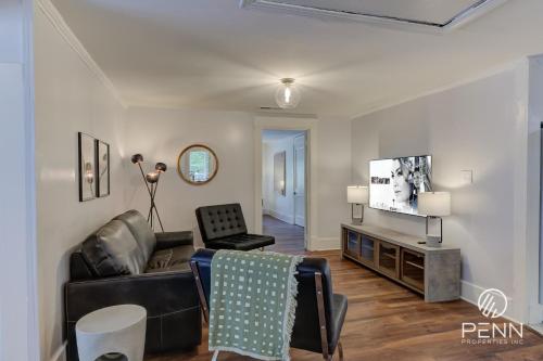 a living room with a couch and a tv at Hideaway Retreat in the Heart of Cooper Young in Memphis