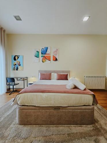 a bedroom with a large bed and a desk at Junção - Apartamentos Completos in Miranda do Douro