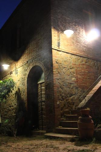 a brick building with stairs and lights on it at Agriturismo Santa Maria in Torrita di Siena