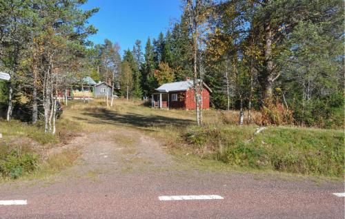a dirt road leading to a red cabin in the woods at Gorgeous Home In Sälen With Sauna in Sälen