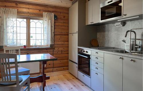 a kitchen with white cabinets and a table and a table sidx sidx sidx at Gorgeous Home In Sälen With Sauna in Sälen