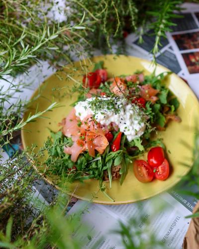 a yellow plate of food with tomatoes and cheese at Eggenberg City Suites - Apartment Amore - Self Check-In in Graz