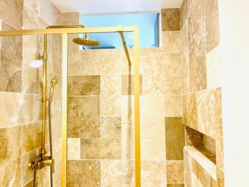 une douche avec une porte vitrée dans une salle de bain dans l'établissement Stylish Loft Paris 17- 3 bdrs - 2 bathrs - 7 pers, à Paris