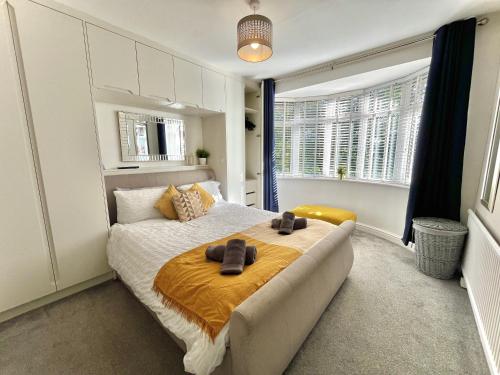 a bedroom with a bed with two slippers on it at Stylish 3-bed home in Prestwich with free parking in Manchester
