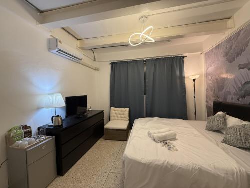a bedroom with a large white bed and a tv at Twenty Two Place Sukhumvit 22 in Bangkok