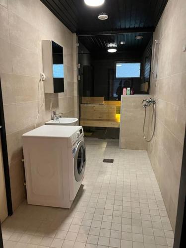 a bathroom with a washing machine and a sink at Saukonkatu in Kokkola